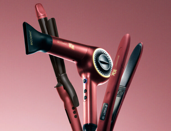 Red and gold Long Barrel Curling Iron, 10X Dryer, and 10X Styling Iron on a pink gradient background