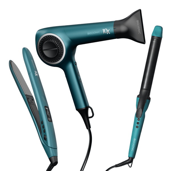 Set of hair styling tools including a hair dryer, straightener, and curling iron on a black background.